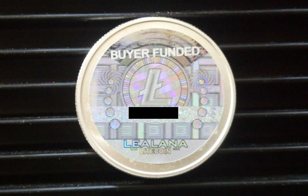 A Lealana 10 LTC piece, now with "BUYER FUNDED" designation on the hologram.